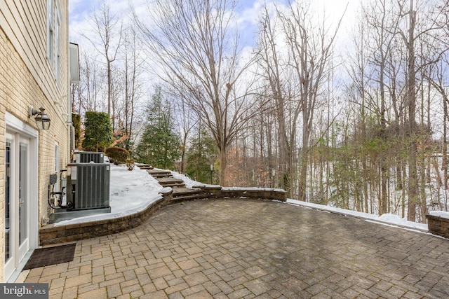 snow covered patio featuring central AC