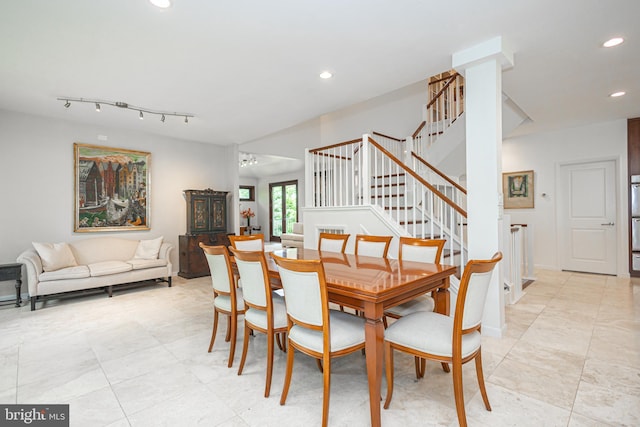 dining room with rail lighting and a chandelier