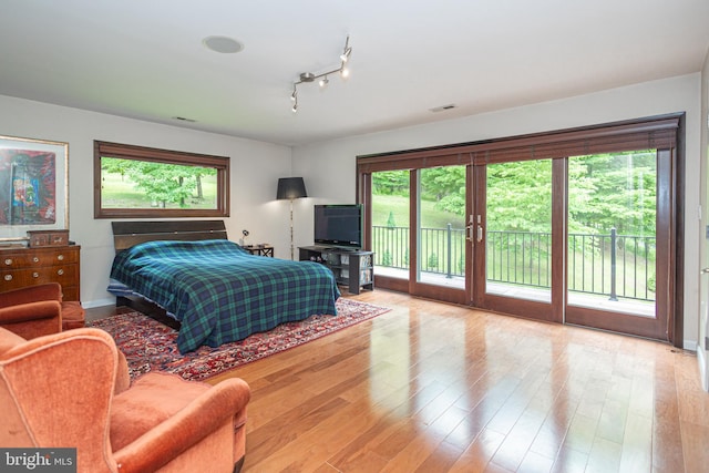 bedroom with access to exterior and light hardwood / wood-style flooring