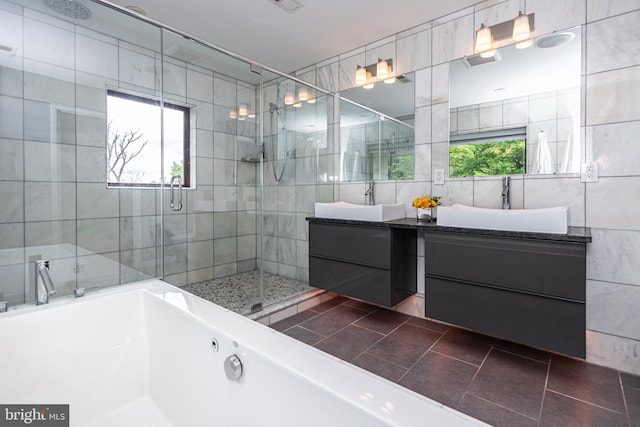 bathroom featuring an enclosed shower, tile patterned floors, tile walls, and a healthy amount of sunlight