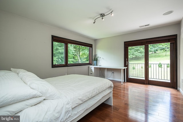 bedroom with hardwood / wood-style floors and access to exterior