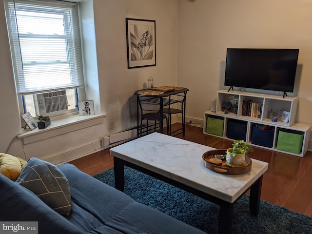 living room with dark hardwood / wood-style flooring and a baseboard heating unit