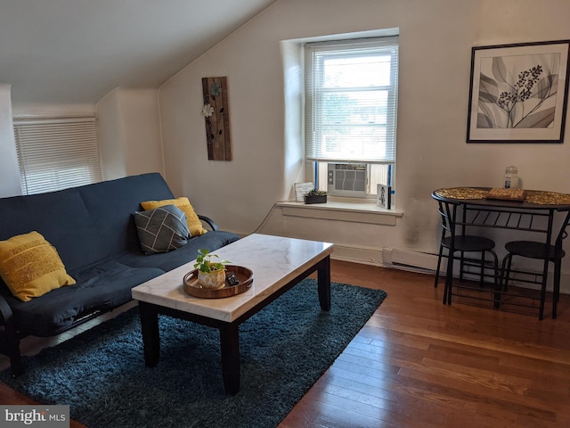 living room featuring cooling unit, lofted ceiling, dark wood-type flooring, and a baseboard heating unit