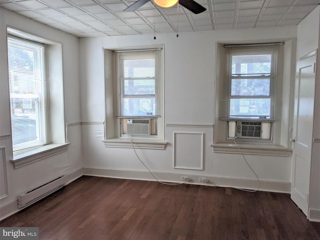 spare room with dark hardwood / wood-style floors, cooling unit, a baseboard heating unit, and ceiling fan