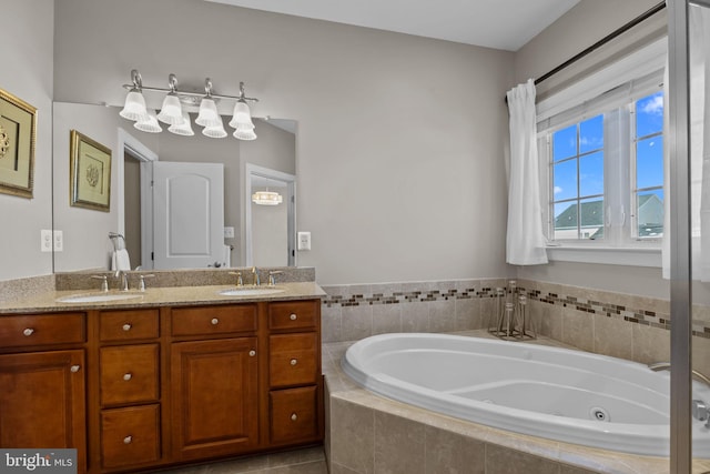 bathroom featuring vanity and tiled bath