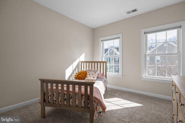 bedroom featuring multiple windows and light colored carpet