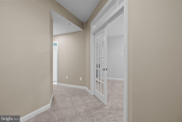 corridor featuring light colored carpet and french doors