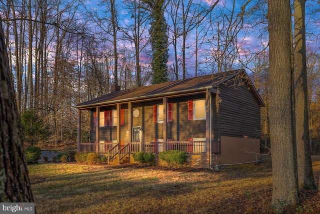 view of front facade featuring a porch and a yard