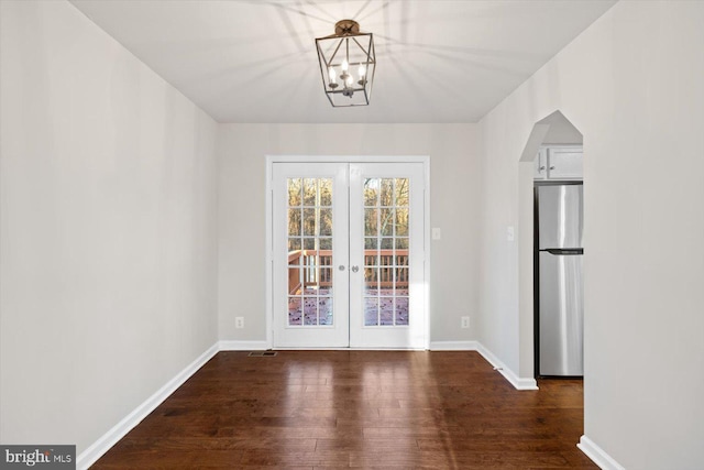 unfurnished dining area featuring a chandelier, french doors, and dark hardwood / wood-style floors