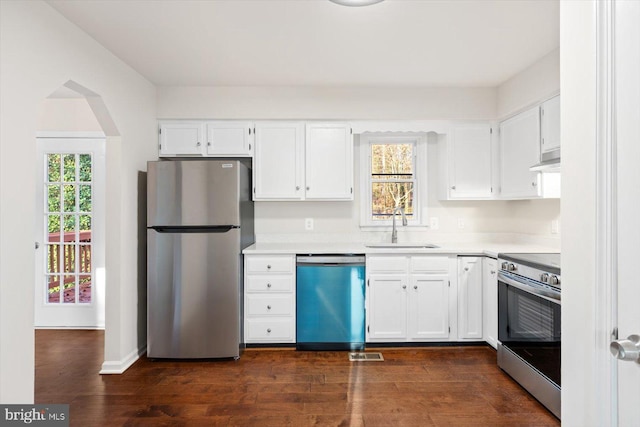 kitchen with dark hardwood / wood-style flooring, a wealth of natural light, stainless steel appliances, sink, and white cabinetry