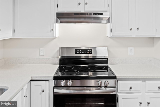 kitchen featuring white cabinets, ventilation hood, and stainless steel electric range oven