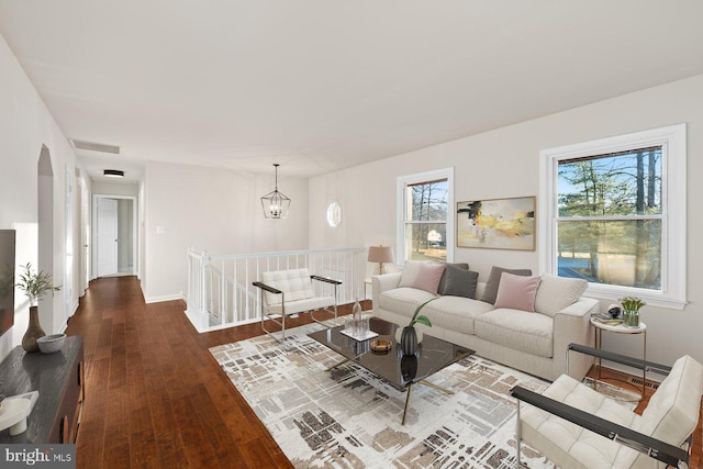 living room with an inviting chandelier, a healthy amount of sunlight, and wood-type flooring