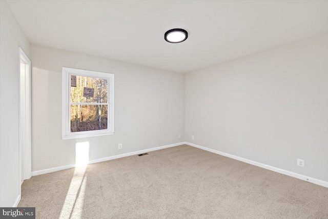 unfurnished room featuring light carpet