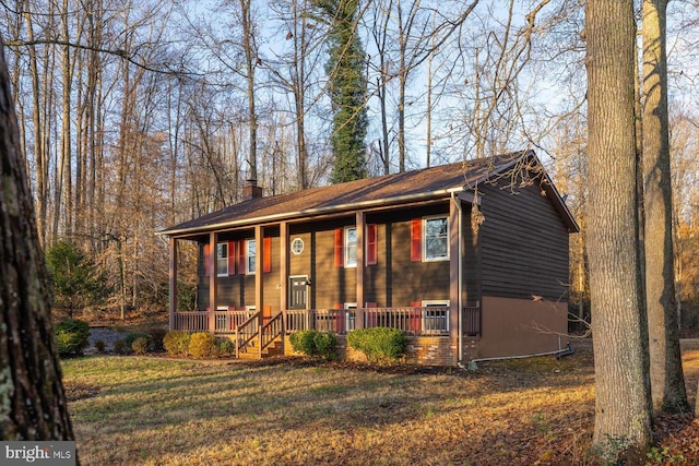 view of front of property featuring covered porch and a front yard