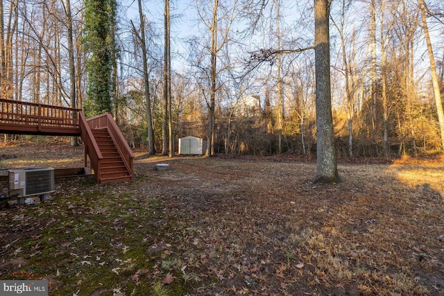 view of yard featuring cooling unit, a shed, and a deck