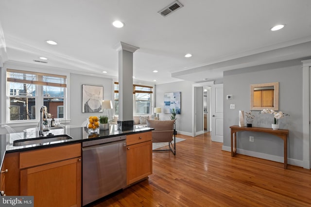 kitchen with sink, stainless steel dishwasher, a wealth of natural light, and hardwood / wood-style flooring