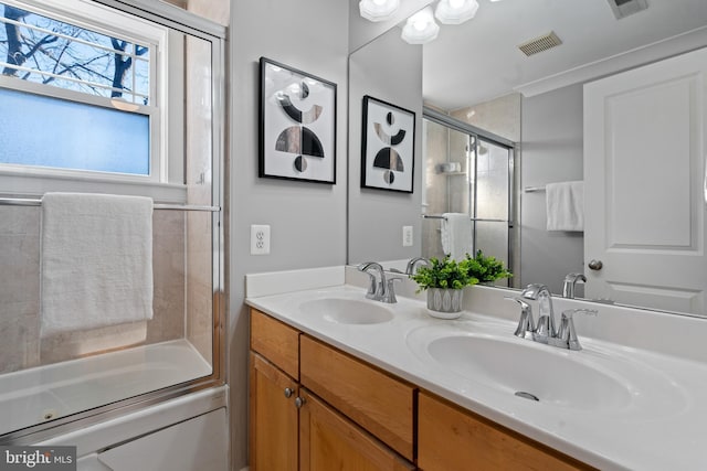 bathroom with vanity and bath / shower combo with glass door