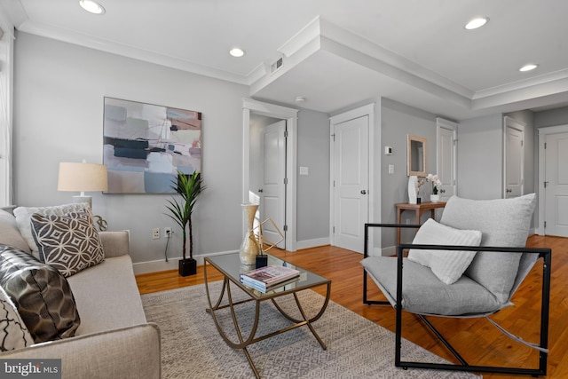 living room with light hardwood / wood-style floors and crown molding