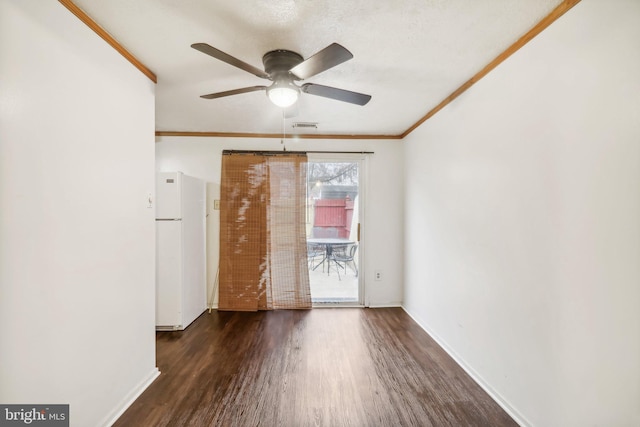 empty room featuring ceiling fan, crown molding, and dark wood-type flooring