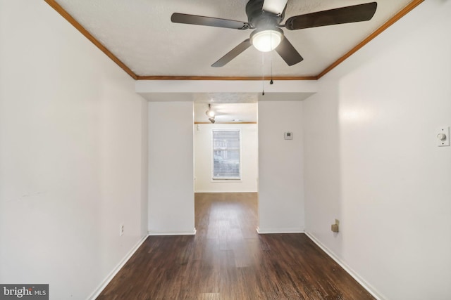 spare room with ceiling fan, crown molding, and dark wood-type flooring