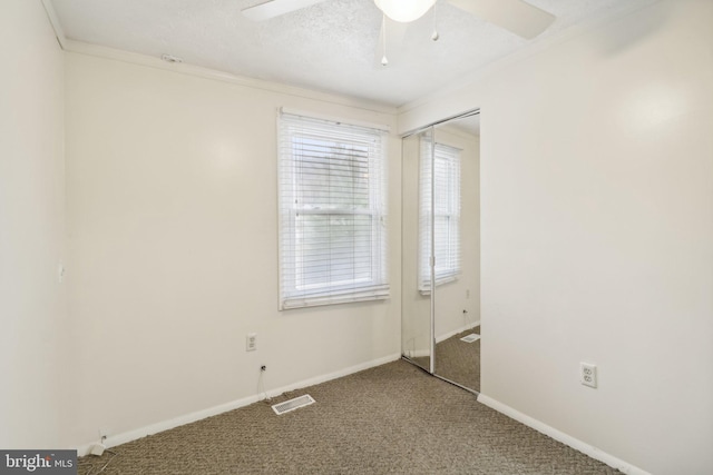 unfurnished room with carpet flooring, ceiling fan, and ornamental molding