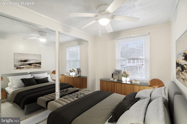 bedroom with ceiling fan, a textured ceiling, and ornamental molding