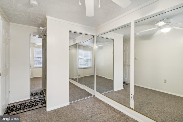 interior space featuring dark colored carpet, ceiling fan, ornamental molding, and multiple windows