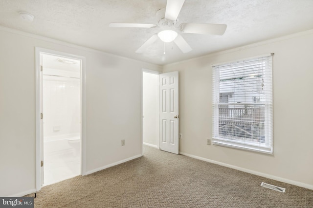 unfurnished bedroom with carpet flooring, ceiling fan, crown molding, and ensuite bath