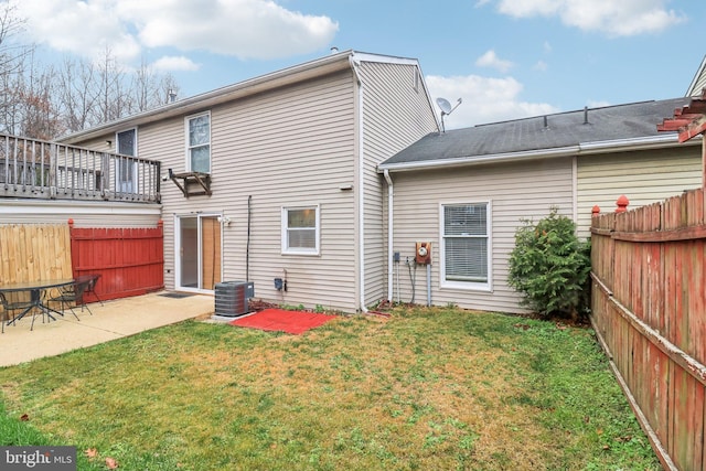 back of property featuring a yard, cooling unit, and a patio