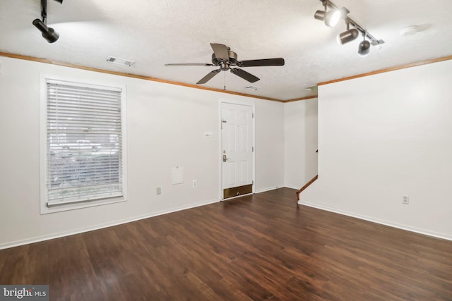 empty room with a textured ceiling, ceiling fan, crown molding, and dark wood-type flooring