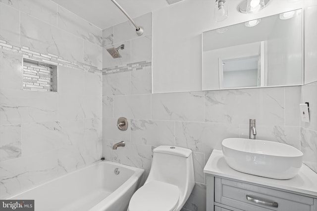 full bathroom with tile walls, backsplash, vanity, toilet, and tiled shower / bath