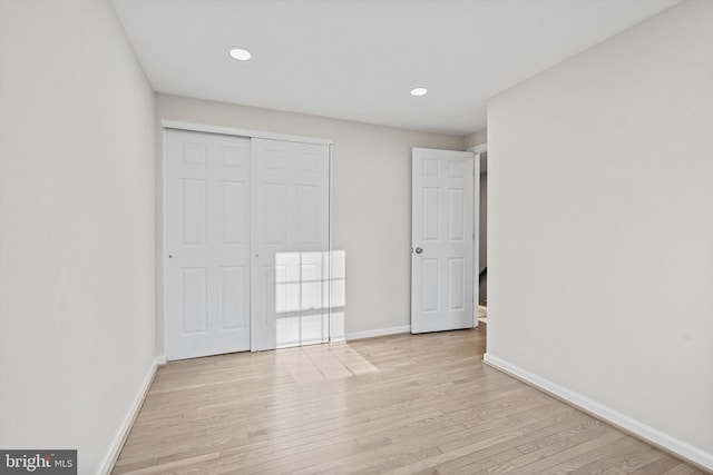 unfurnished bedroom featuring a closet and light wood-type flooring