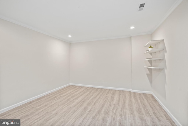 empty room featuring crown molding and light wood-type flooring