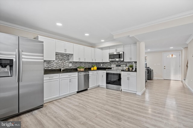 kitchen featuring white cabinetry, appliances with stainless steel finishes, sink, and light hardwood / wood-style flooring