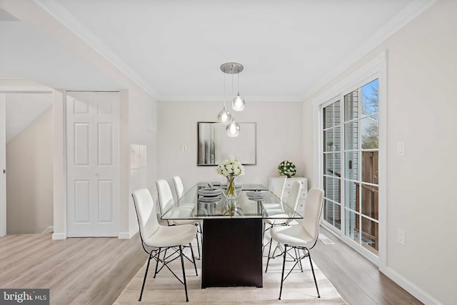 dining area featuring crown molding and light wood-type flooring