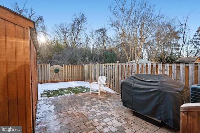 snow covered patio with cooling unit and area for grilling