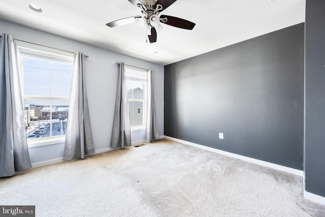 carpeted empty room with ceiling fan and a healthy amount of sunlight