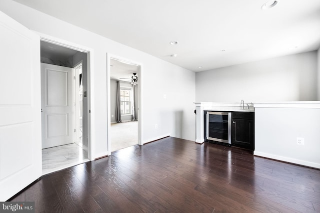 interior space with wine cooler, ceiling fan, dark hardwood / wood-style flooring, and indoor wet bar