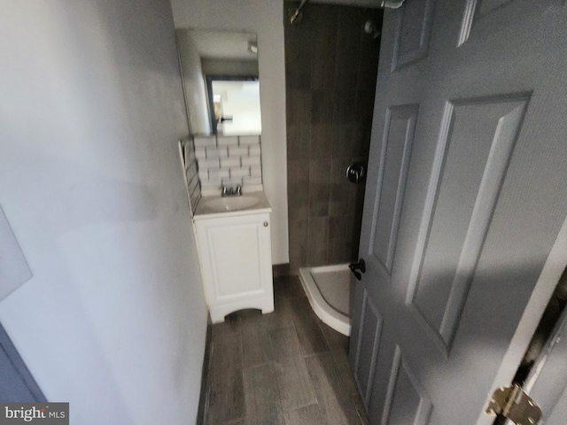 bathroom featuring a tile shower, vanity, and hardwood / wood-style floors