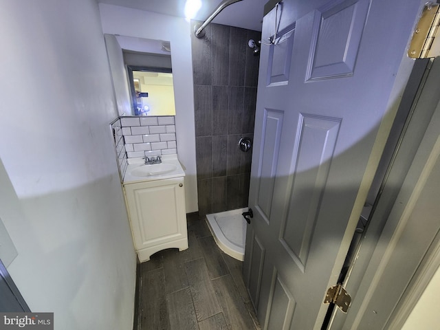 bathroom featuring backsplash, vanity, and tiled shower