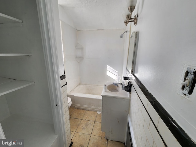 full bathroom featuring tile patterned flooring, washtub / shower combination, toilet, and sink