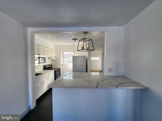 kitchen with white cabinets, stainless steel appliances, light stone counters, and tasteful backsplash