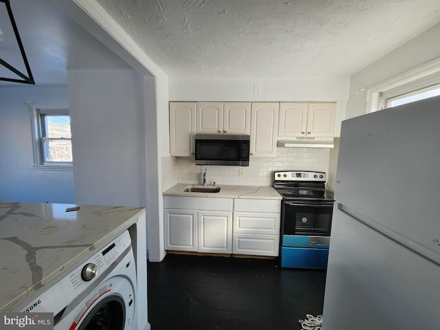 kitchen with sink, washer / dryer, decorative backsplash, white cabinets, and appliances with stainless steel finishes