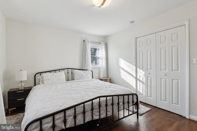 bedroom with dark hardwood / wood-style flooring and a closet