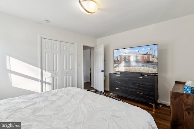 bedroom with a closet and dark hardwood / wood-style floors