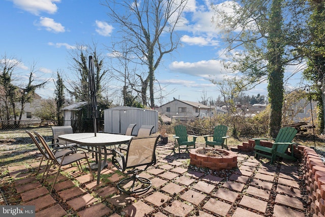 view of patio with a storage unit and an outdoor fire pit