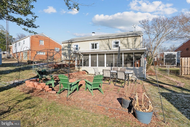 back of property featuring a patio, a sunroom, and a lawn