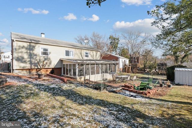 back of house with a lawn and a sunroom