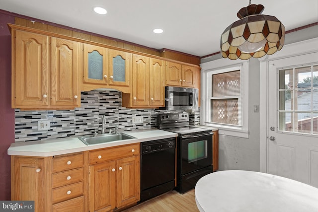 kitchen with sink, tasteful backsplash, crown molding, decorative light fixtures, and black appliances