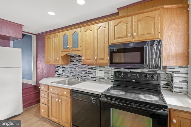 kitchen featuring decorative backsplash, sink, black appliances, and light hardwood / wood-style floors